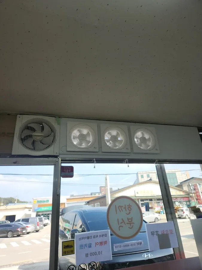 상가 출입구 상단 유리창 위쪽에 설치된 기존 환풍기 네 대