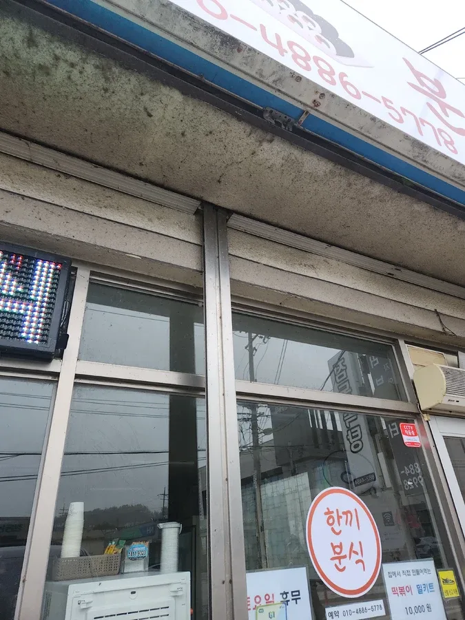상가 외벽 셔터와 간판 위쪽 외벽 마감이 보이는 모습