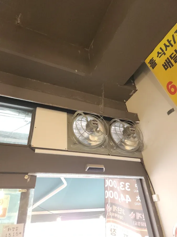 출입구 위쪽 좁은 벽면에 환풍기 두 대가 나란히 달린 모습