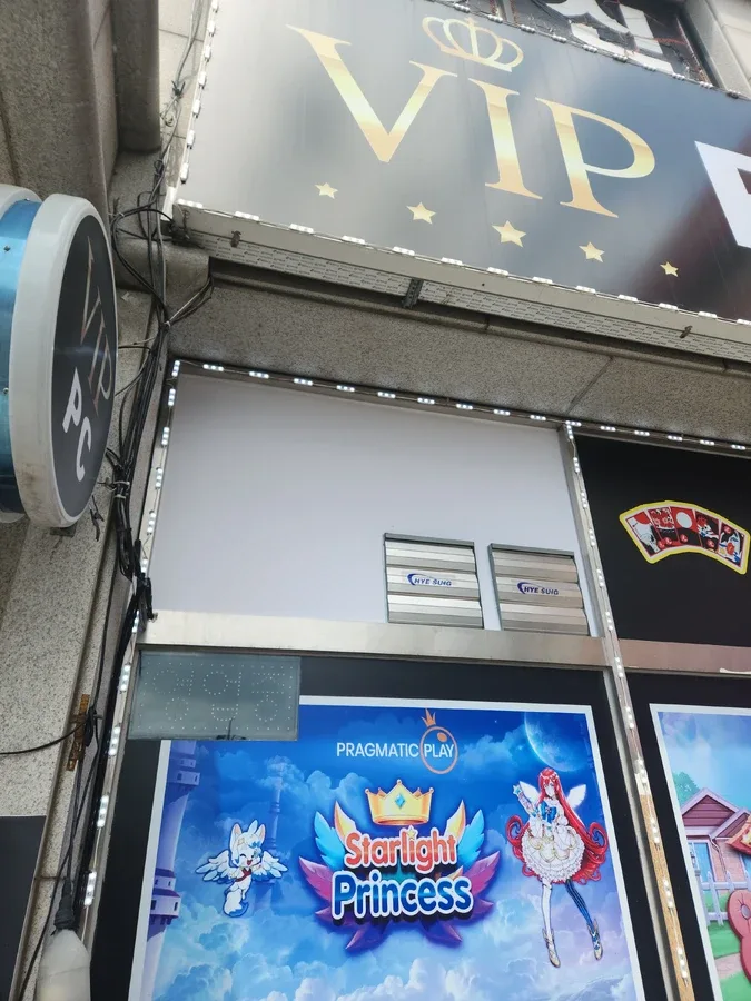 건물 외벽 간판 아래 유리창과 외벽 마감이 보이는 상가